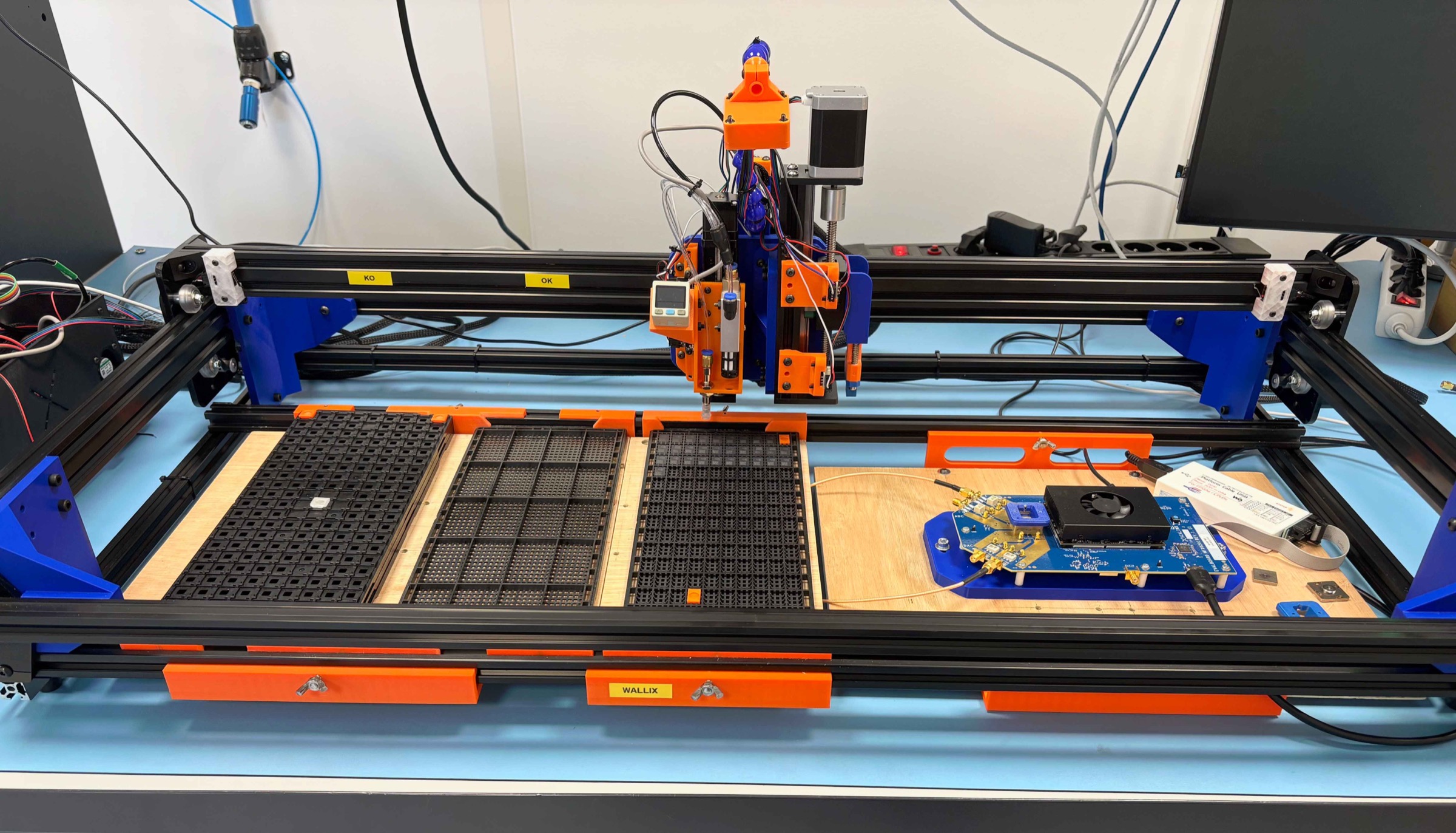 Robot de manipulation de composants électroniques installé sur un banc de laboratoire pour tests automatisés